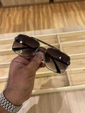 Gunmetal navigator sunglasses - held in hand showing full frame front